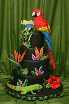 a cake decorated with birds, flowers and plants on top of a green tablecloth