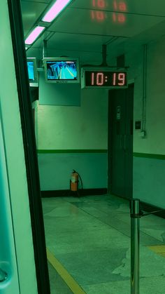 an exit way with the time displayed in front of it and a fire extinguisher nearby