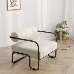 a white chair sitting on top of a hard wood floor next to a glass table