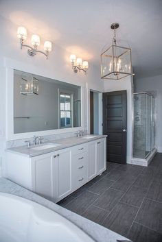 a large bathroom with two sinks and a bathtub next to a walk in shower