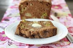 a piece of bread sitting on top of a white plate next to a slice of cake