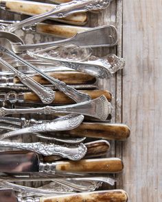 an assortment of silverware is displayed in a wooden box