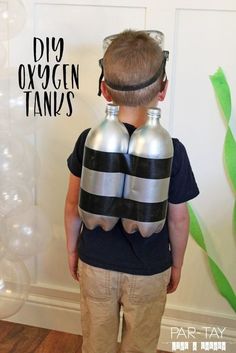 a young boy wearing two oxygen tanks in front of a balloon wall with the words diy oxygen tank's on it