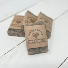 three bars of soap sitting on top of each other next to some brown paper tags