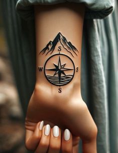 a hand with a compass tattoo on it