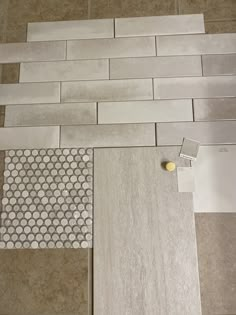 the floor is being remodeled with white and gray tiles on it, along with other tile samples