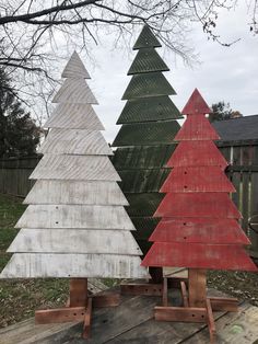 three wooden christmas trees sitting on top of a wooden table