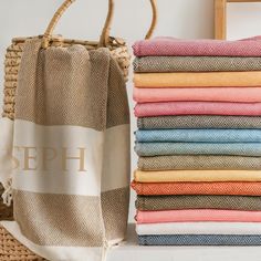 a stack of towels sitting on top of a table next to a basket