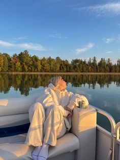 a woman sitting on top of a boat in the water