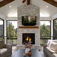 a living room filled with furniture and a flat screen tv mounted on the wall above a fire place