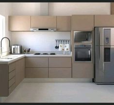 a modern kitchen with beige cabinets and stainless steel appliances, including a refrigerator freezer