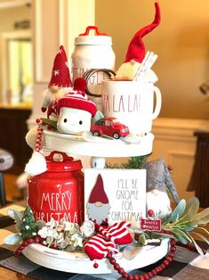 a table topped with cups and saucers covered in christmas decorations on top of a plate