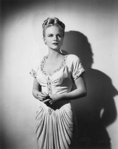 black and white photograph of a woman in a dress with her hands on her hips