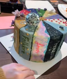 a person cutting into a colorful cake on top of a table