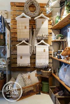 towels are hanging on the wall in a room with wooden shelves and baskets filled with items