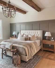 a bedroom with a large bed and chandelier hanging from it's ceiling