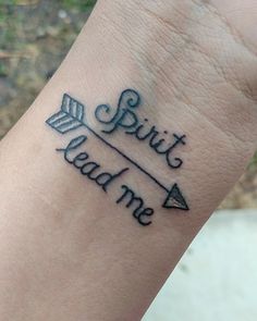 a wrist tattoo with an arrow and the words spirit lead me