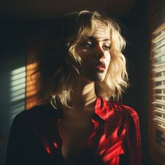 a woman standing in front of a window with blinds on the side and her eyes closed