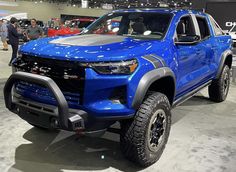 a blue truck is on display at an auto show