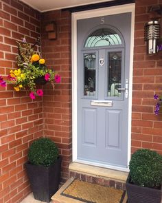 the front door is decorated with flowers and potted plants