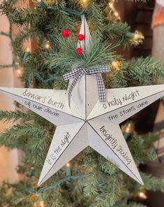 a christmas tree with a star ornament hanging from it's side and writing on the bottom