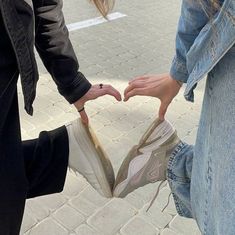 two people touching their shoes on the street