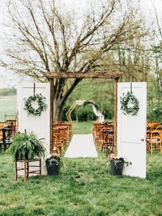 an outdoor ceremony set up with chairs and greenery