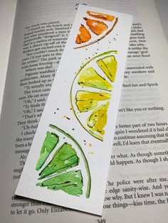 an open book with watercolors on it and some lemons in the pages