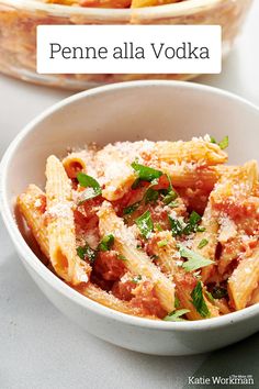 a white bowl filled with pasta covered in sauce and parmesan cheese