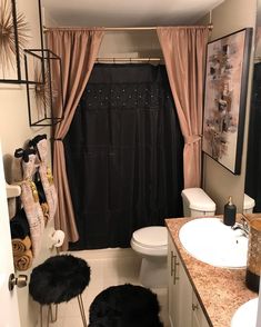 a bathroom with a sink, toilet and shower curtain in it's center area