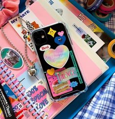 an iphone case sitting on top of a blue tray filled with papers and other items