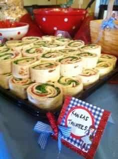 there are many rolls on the table with christmas decorations around them and a gift box