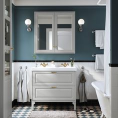 a bathroom with blue walls and white cabinets, black and white checkered flooring