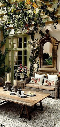 a living room filled with lots of furniture and flowers on the wall above it's windows