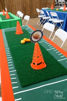 an orange cone sitting on top of a green field next to white chairs and tables