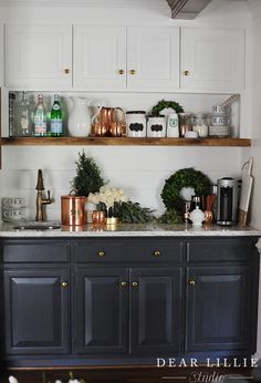 a kitchen with black cabinets and white walls