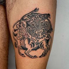 a black and white tattoo on the leg of a man's legs with an animal design