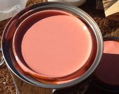 a metal bucket filled with pink liquid on top of a wooden table next to other items