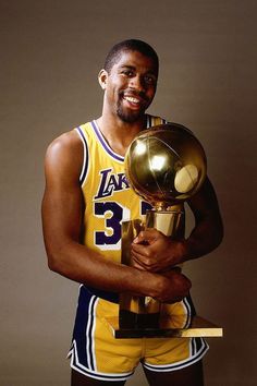 a man holding a trophy in his right hand and wearing a basketball uniform with the number 33 on it