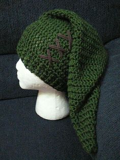 a knitted green hat on top of a mannequin head