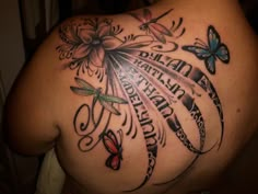 the back of a woman's shoulder with tattoos on it and butterflies flying around