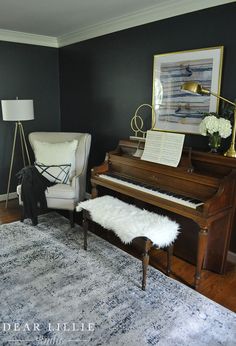 a living room with a piano, chair and rug in the middle of the room