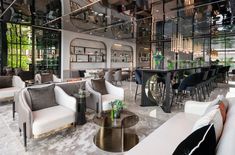 a living room filled with white furniture and lots of glass walls on top of it