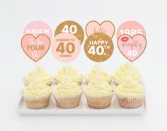 cupcakes with pink and gold frosting are arranged on a plate in the shape of hearts