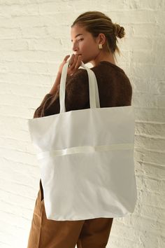 White A versatile 2-way bag that switches effortlessly from shoulder bag to handbag. Fold it and use small removable strap to pack down to a small rectangle for easy carrying. Super lightweight, durable and water resistant 1.9oz ripstop nylon (100% nylon) Zipper closure, inner zipper pocket, unlined interior shoulder bag - 18.5" (W) 19.5" (H) 5" (D) 10" drop Hand bag - 18.5" (W) 12" (H) 45" (D) 2.5" drop Made in USA Functional White Shoulder Bag For Errands, Rectangular Nylon Shoulder Bag For Everyday, White Nylon Shoulder Bag For Travel, Large Capacity White Nylon Bags, White Bags With Reinforced Handles, Rectangular Nylon Shoulder Bag With Top Carry Handle, Versatile Nylon Bag With Reinforced Handles, Nylon Shopping Bag With Detachable Strap, Nylon Bags With Reinforced Handles