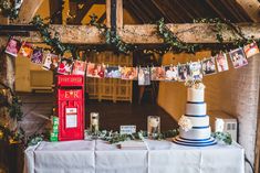 a table topped with a cake next to a red phone booth and pictures on the wall