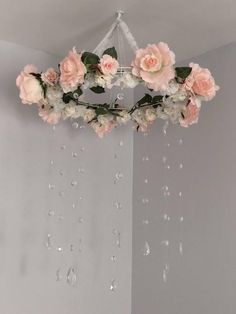 a chandelier with pink flowers hanging from it's sides and water droplets on the ceiling