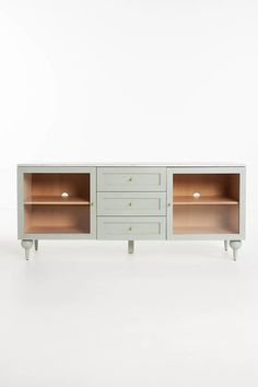 the sideboard has two open shelves on one end and three drawers on the other