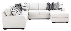 a white sectional couch with black and white pillows