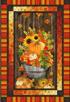 an autumn quilt with pumpkins and sunflowers in a basket on a wooden fence